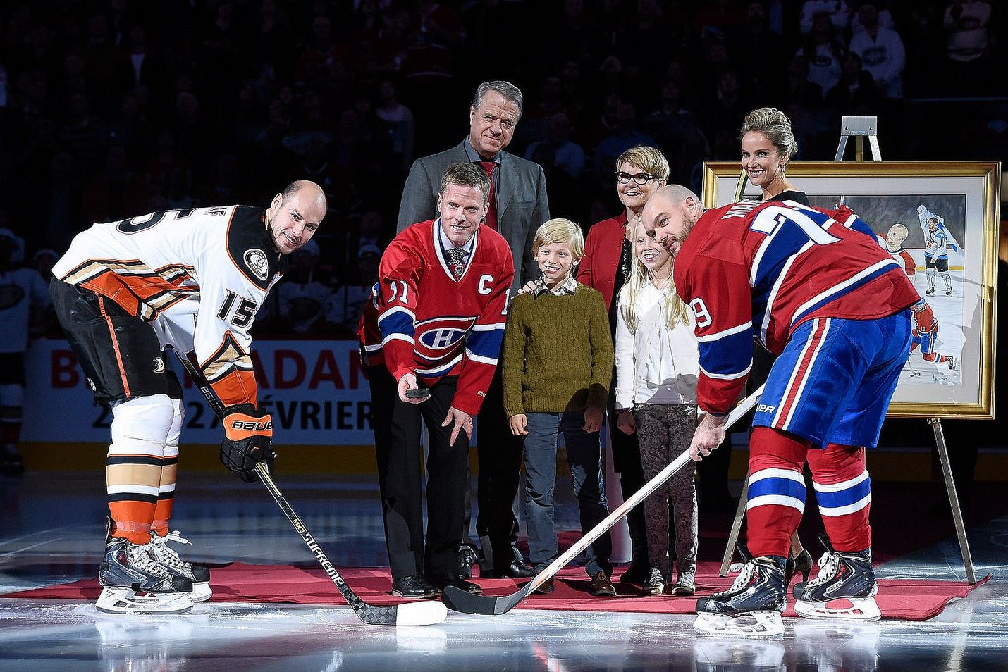 Saku Koivu perheineen ottelun avausseremoniassa kapteenien Ryan Getzlafin (vas) ja Andrei Markovin kanssa.