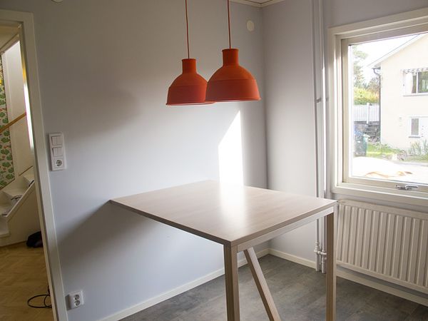 Köksbord i samma höjd som arbetsbänken. Lamporna kommer från danska Muuto.