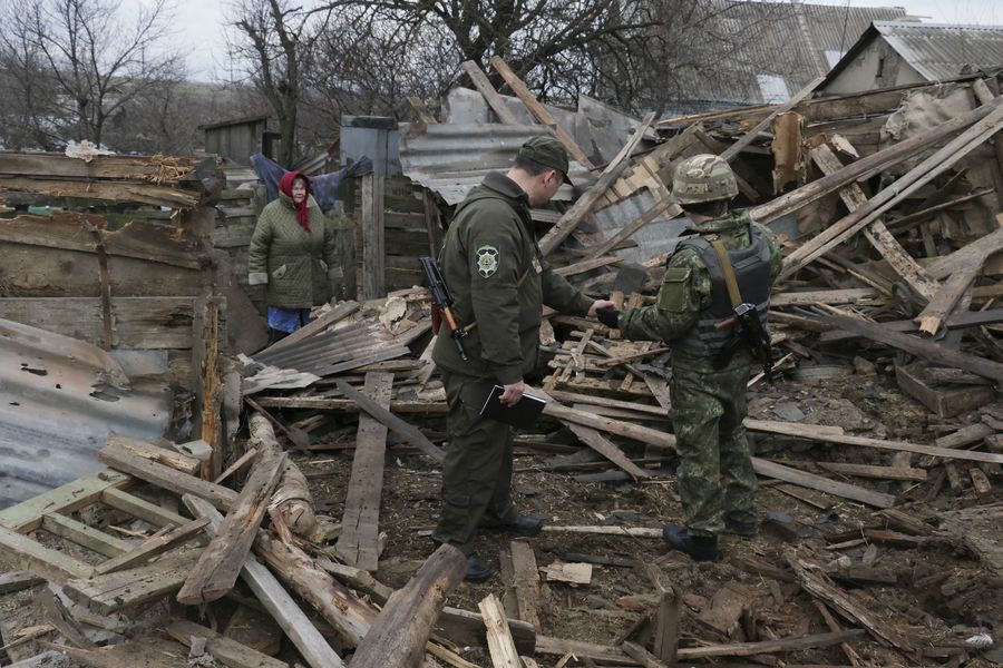 Ukrainalaiset käyvät läpi iskuissa tuhoutuneet rakennuksen raunioita Mariupolissa Ukrainassa 5. helmikuuta 2015. EPA/SERGEY VAGANOV