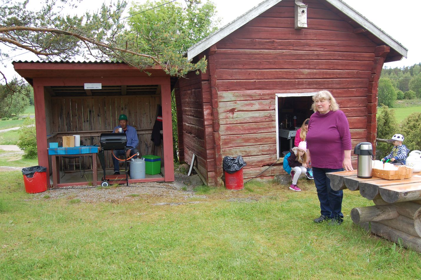 Juhannusjuhlilla oli tarjolla myös makkaraa ja kahvia. Tärkeintä monille tapahtumassa on muiden kyläläisten tapaaminen. Kuva: Elina Lammela