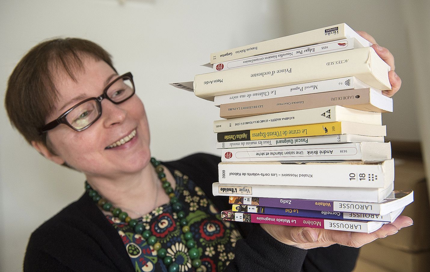 Osastonhoitaja Maisa Hyytinen esittelee ranskankielisten kirjojen pinoa. Nämäkin kirjat ovat tulleet Rauman kaupunginkirjastoon yksityisen henkilön lahjoituksena.