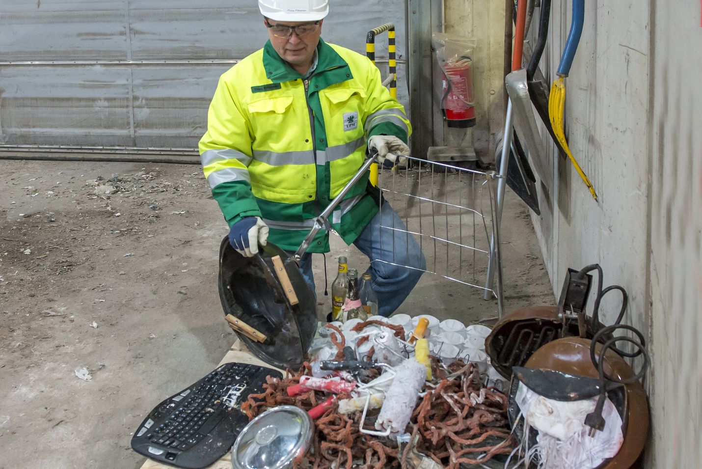 Rauman Biovoiman toimitusjohtaja Timo Pitkänen esitteli jätehallissa energiajätteen joukosta poimittuja tavaroita. Kasasta löytyi muun muassa pallogrilli ja tietokoneen näppäimistö.