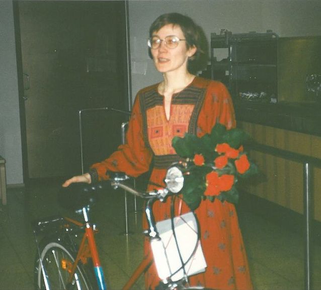 Nuolijärvi in the karonkka of her doctoral defence, as the proud owner of a bicycle and a book of poetry, given by colleagues from KOTUS and the Department of Finnish.​