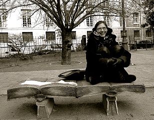 Anna Baijars sitting on a book in Paris.​