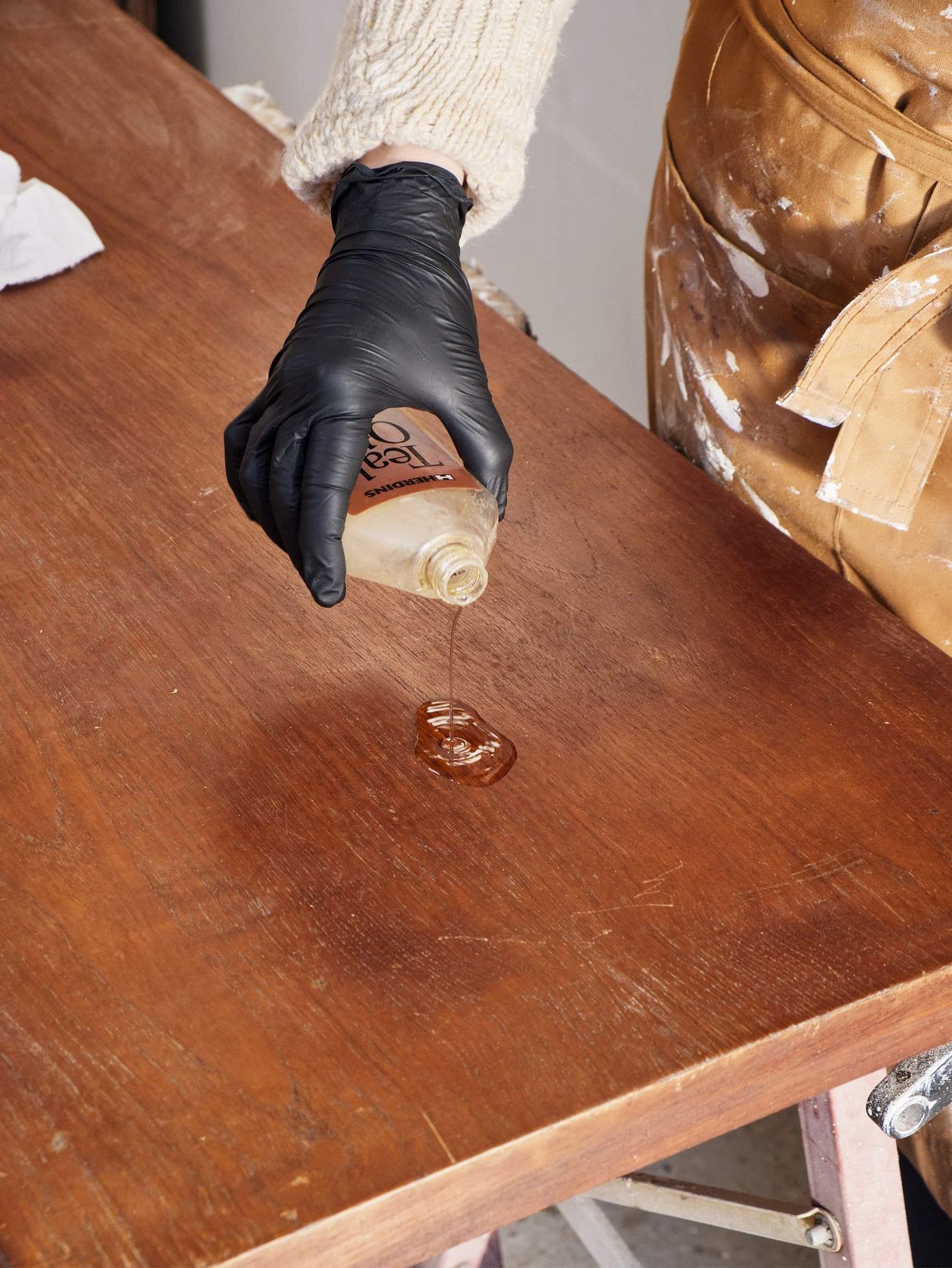 Pouring oil on old teak table