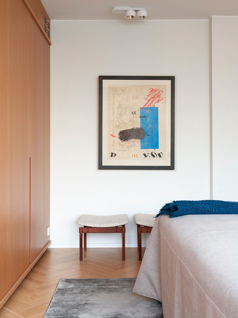 A bedroom with an artwork on the wall