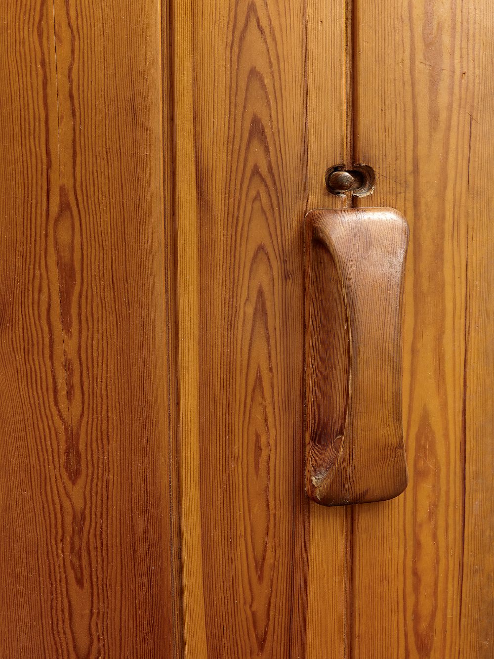 Detail of a wooden sauna door handle.