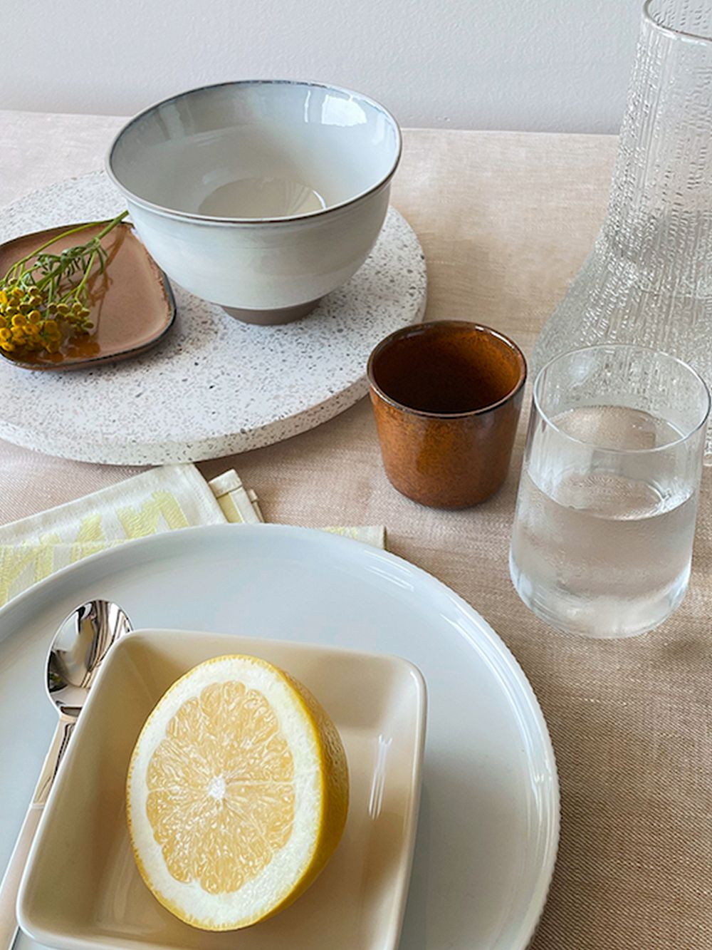 An image featuring, among others, the Bernadotte porcelain plate and Bernadotte crystal glass by Georg Jensen, Lyngby Porcelin's Lyngby vase, and Gense's Nobel spoon in a table setting, as part of the dining room decor. 