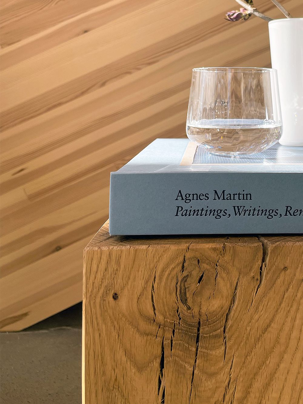 Nikari Biennale stool used as a side table, with a book and a glass of water on top