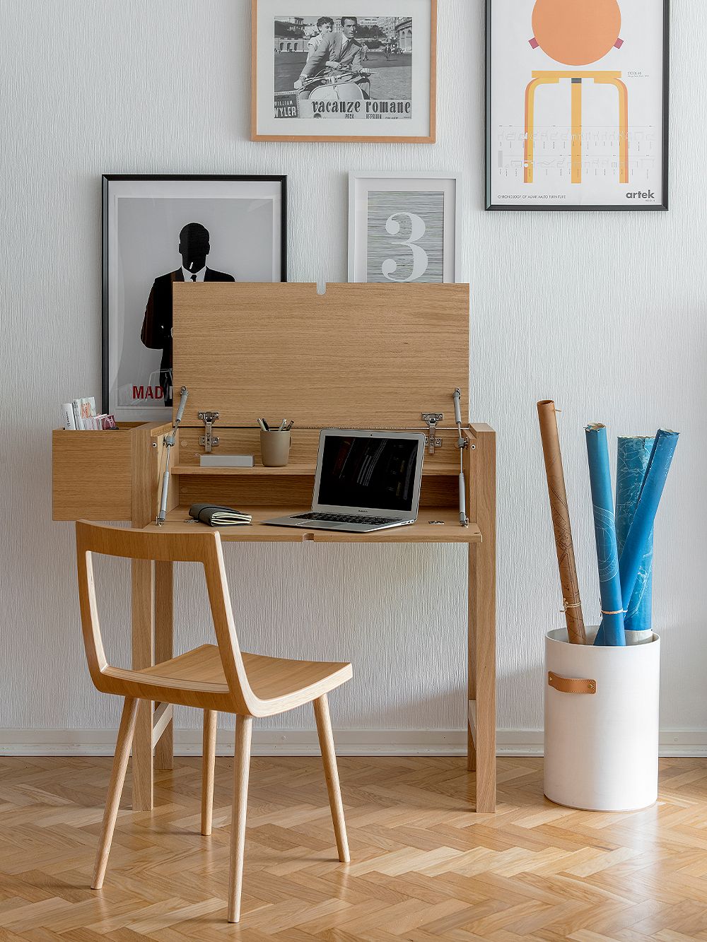Tapio Anttila's Jat-ko desk opened with a laptop and various office supplies inside. In front of the desk is a wooden Viiva chair.