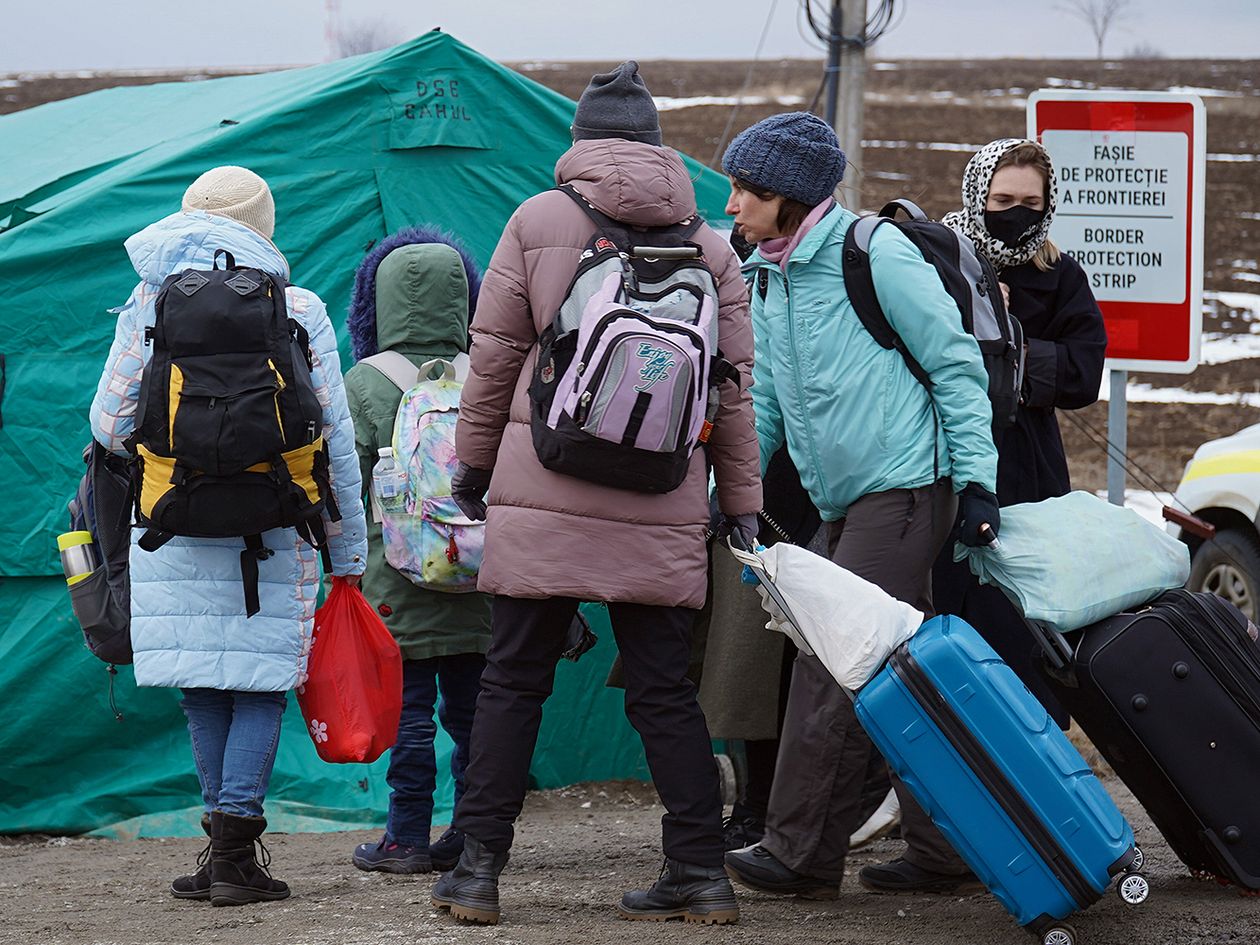 Ukrainian refugees with backpacks and suitcases
