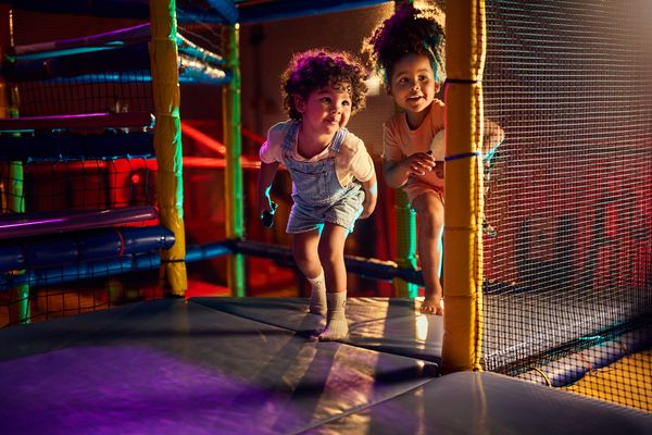 Kinderen spelen en lachen in de vernieuwde Indoor Speelwereld BALUBA in Park Eifel. Ze glijden van een indrukwekkende klimvulkaan met glijbaan en genieten van de nieuwe speelelementen.