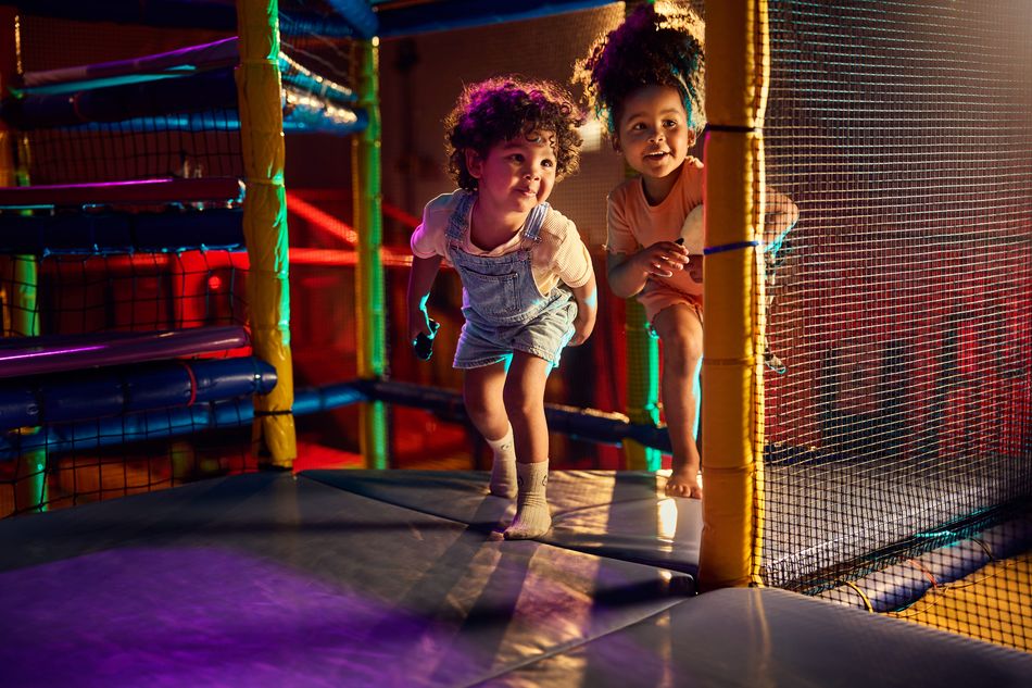 Kinderen spelen en lachen in de vernieuwde Indoor Speelwereld BALUBA in Park Eifel. Ze glijden van een indrukwekkende klimvulkaan met glijbaan en genieten van de nieuwe speelelementen.