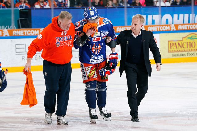 Juhani Jasu poistui Kai Kantolan taklauksen jälkeen jäältä vertavuotavana huoltajien tukemana. Kuva: Jukka Rautio / Europhoto
