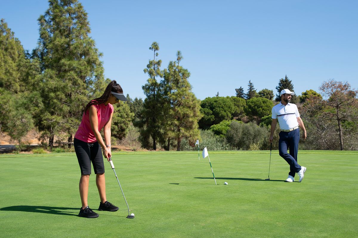 Homme et femme jouant au golf sur une pelouse verte
