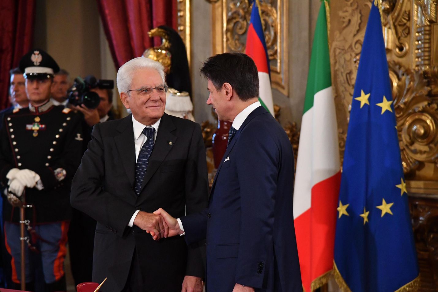 Italian pääministeri Giuseppe Conte (oik.) kättelee presidentti Sergio Mattarellaa torstaina tilaisuudessa, jossa maan uusi hallitus vannoi virkavalansa.