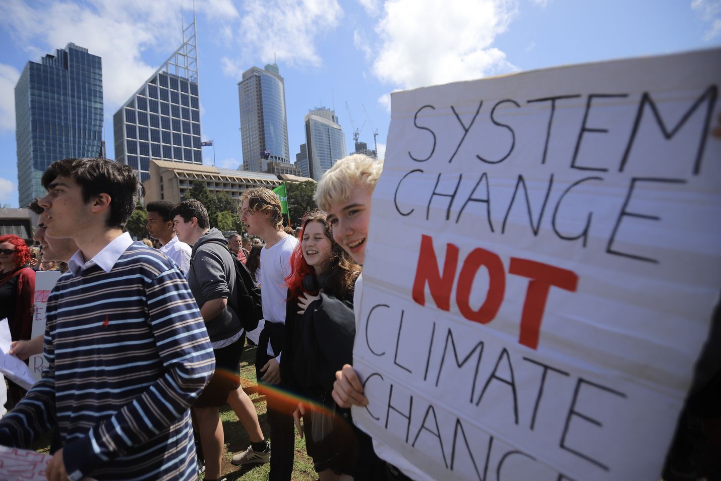 "Järjestelmän muutos, ei ilmaston muutos" lukee nuorten mielenosoittajien julisteessa ilmastoprotestin aikana Australian Sydneyssä perjantaina.