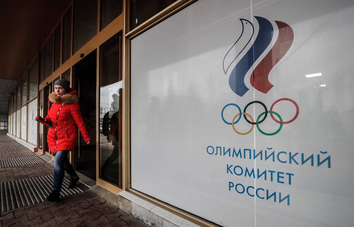 Venäläinen nainen poistuu Venäjän olympiakomitean toimistosta Moskovassa maanantaina.