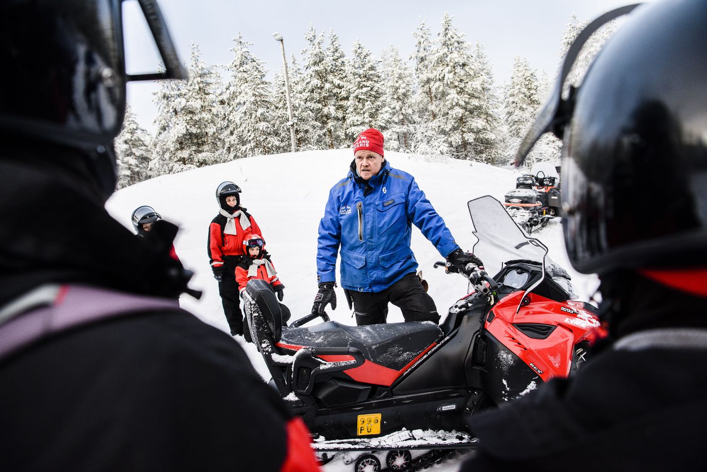 Lapland Safariksen palkkalistoilla on noin 750 ohjelmapalvelutyöntekijää eri puolilla Lappia. Tässä Rovaniemen toimipisteen opas Ismo Pasanen ohjeistaa ulkomaalaisia matkailijoita moottorikelkan käyttöön.