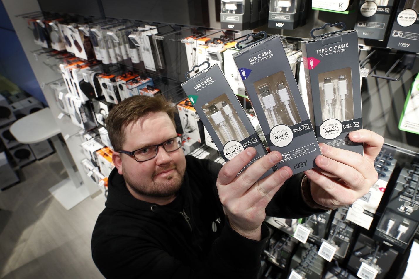 Näillä mennään. Telian myymälässä muiden muassa latureita myyvä Julius Mäkelä esittelee nykyisen perussetin. Siihen kuuluvat micro-USB ja USB-C sekä Applen Lightning.
