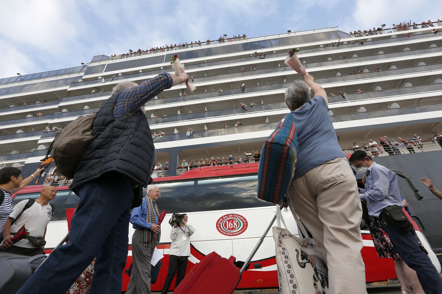 Matkustajat heiluttivat lähtiessään MS Westerdam -risteilyalukselta Sihanoukvillen satamassa Kambodzhassa perjantaina. Useat muut maat käännyttivät laivan pois, koska pelkäsivät, että aluksella on koronavirustapauksia.
