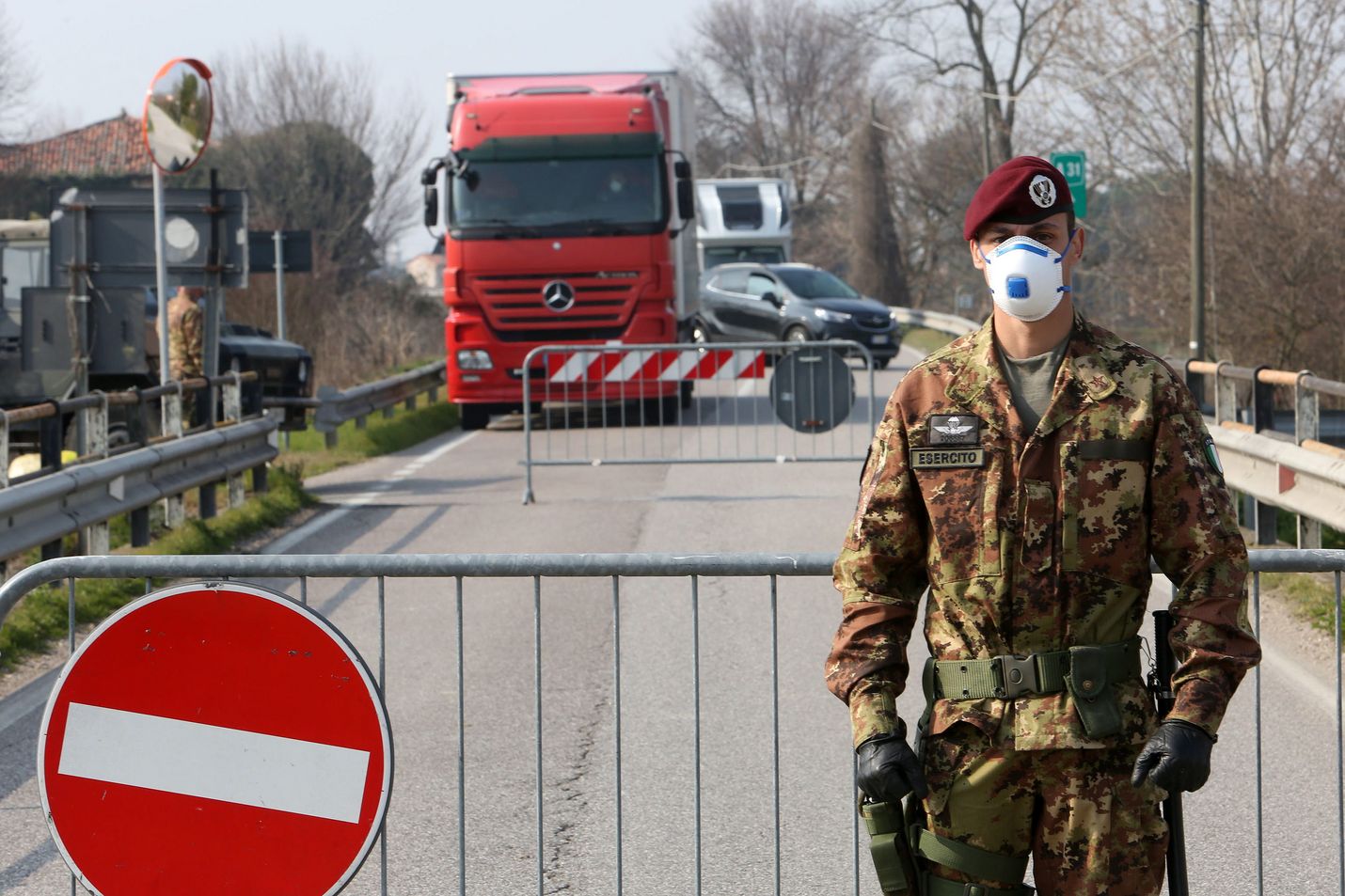 Italian armeijan sotilas seisoi maanantaina tiesululla pikkukaupunkiin johtavalla tiellä Pohjois-Italiassa, jossa kymmeniä kaupunkeja on eristetty koronaviruksen leviämisen takia.