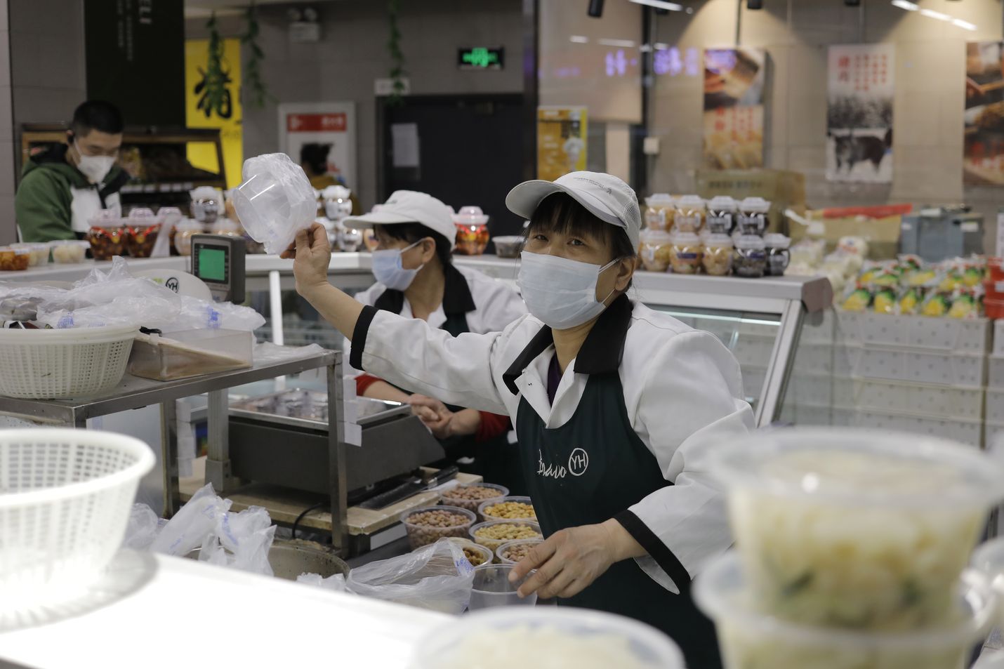 Myyjällä oli kasvoillaan suojamaski kun hän työskenteli Pekingissä sijaitsevassa supermarketissa tiistaina. Maanantaina ei Kiinassa raportoitu enää uusista paikallisesti levinneistä koronavirustartunnoista Hubein maakunnan ulkopuolella.
