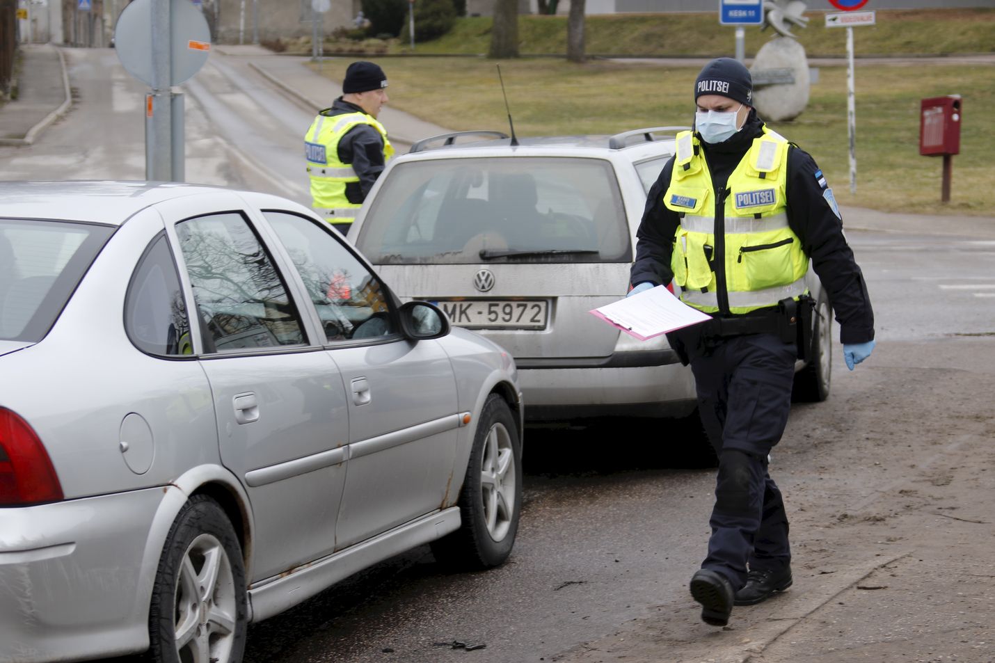 Viron poliisit tarkastivat matkustusasiakirjoja Valgassa Latvian rajalla tiistaina. Kaksoiskaupungin asukkaat saivat liikkua rajan yli töihin rajan sulkemisesta huolimatta.
