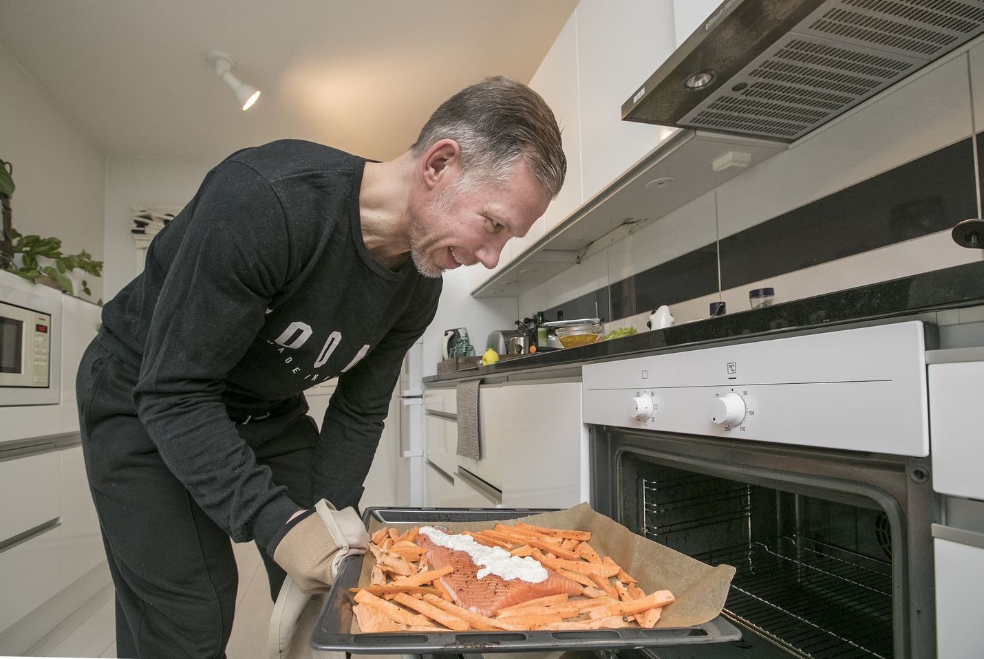 Samppa Jaakola valmistaa uunilohen ja bataatit samalla uunipellillä.