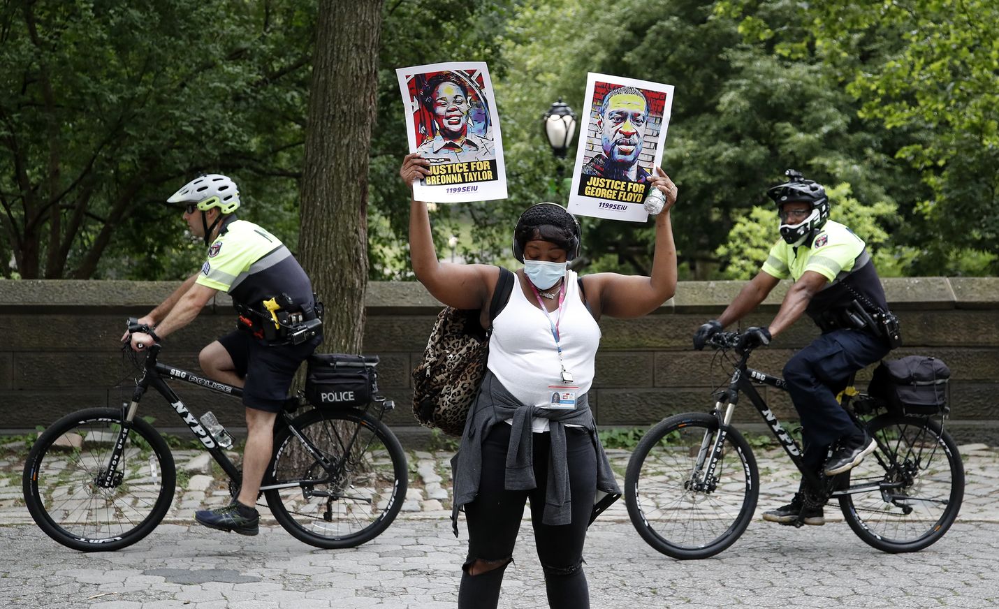Mielenosoittajalla oli kädessään sekä Breonna Taylorin että George Floydin kuvat protestissa New Yorkissa aiemmin kesäkuussa.