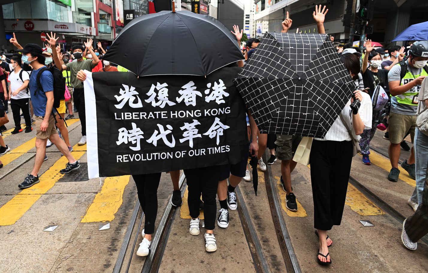 Mielenosoittajat vaativat Hongkongin vapauttamista keskiviikkona. Vastaavista kylteistä voi poliisin mukaan joutua nyt vastuuseen.