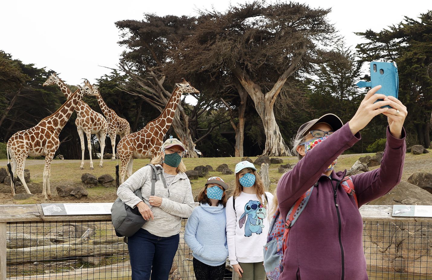 San Franciscon eläintarha avautui melkein neljän kuukauden tauon jälkeen maanantaina. Perhe otti selfien kirahvin kanssa. Kalifornian pahan koronatilanteen vuoksi kävijöiltä vaaditaan maskeja ja turvavälejä.