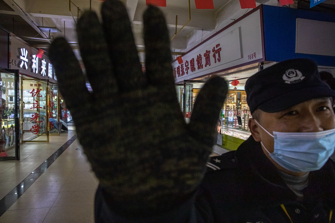 Vartija yritti estää valokuvaajaa kuvaamasta Huananin kalatoria Kiinan Wuhanissa viime joulukuussa. Koronaviruksen alkuperä jäljitettiin yli vuosi sitten sinne.