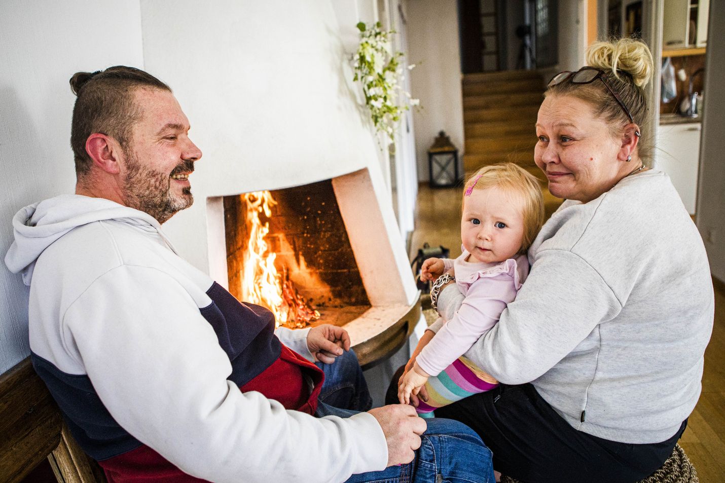 Mika Pajuniemen ja Satu Uraston lapsenlapsi Emma Leinonen nauttii takkatulen lämmöstä.
