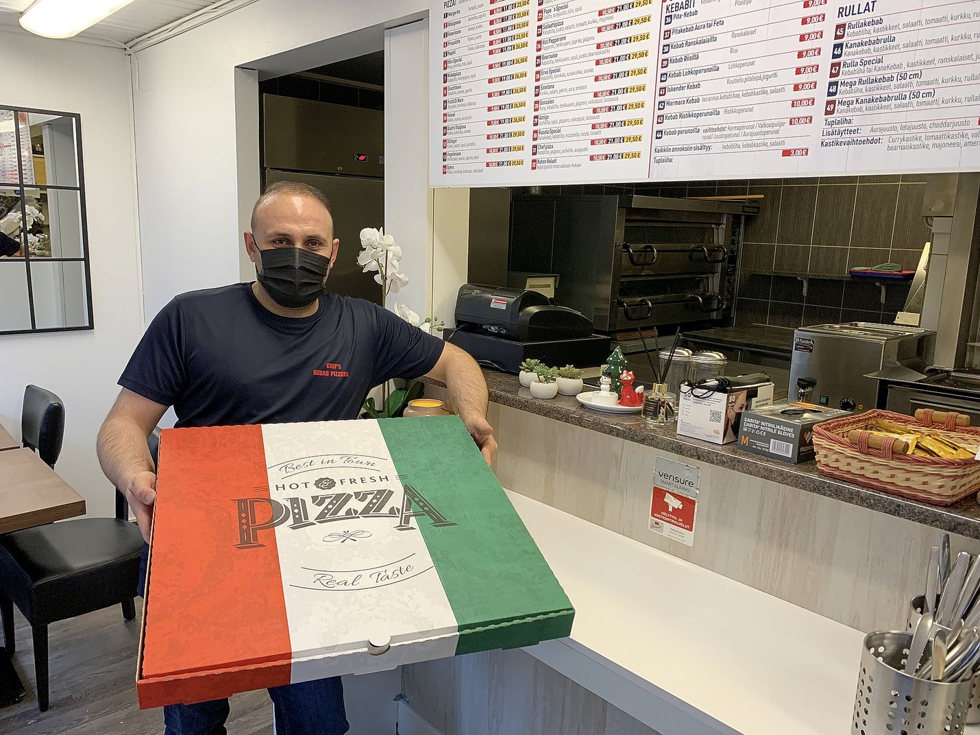 Kun pizza on halkaisijaltaan 60 senttimetriä, riittää siinä syötävää vaikka isommallekin joukolle. Yrittäjä Hayrettin Aksoylu esittelee jättipizzan take away -boksia.