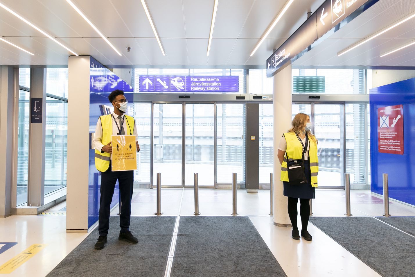 Lentoliikenne oli ensimmäisiä maskit käyttöön ottaneita aloja. Matkustajia opastettiin Helsinki-Vantaan lentoasemalla heinäkuussa 2020.