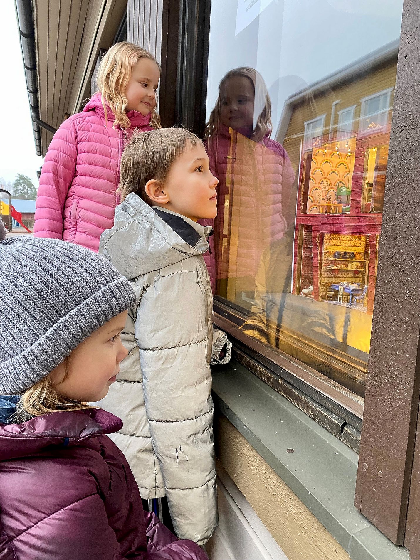 Lapijoen koulun tokaluokkalaiset Hilma Leivo (takana), Samuli Vuorinen ja Amanda Kanerva ovat iloisia siitä, että Elmeri-tonttu toi koko perheensä täksi jouluksi Lapijoelle. Tonttulassa ja tonttukoulussa tapahtuu joka päivä jotain jännää.