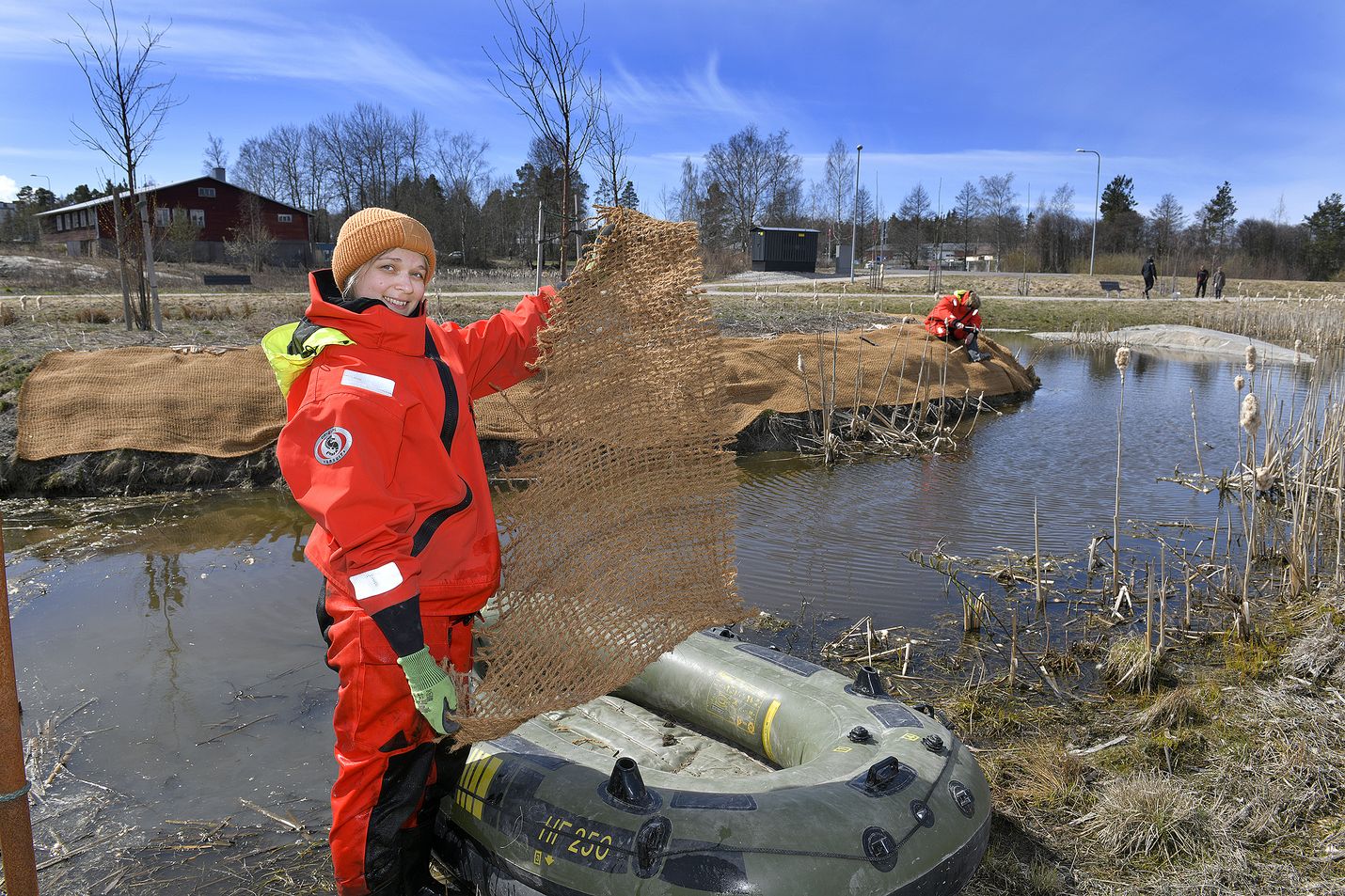 Pyhäjärvi-instituutin Elisa Mikkilä (edessä) ja Reija Hietala asensivat eroosiomattoa Papinpellon kosteikon tekosaarille. Matto maatuu paikalle vähitellen.
