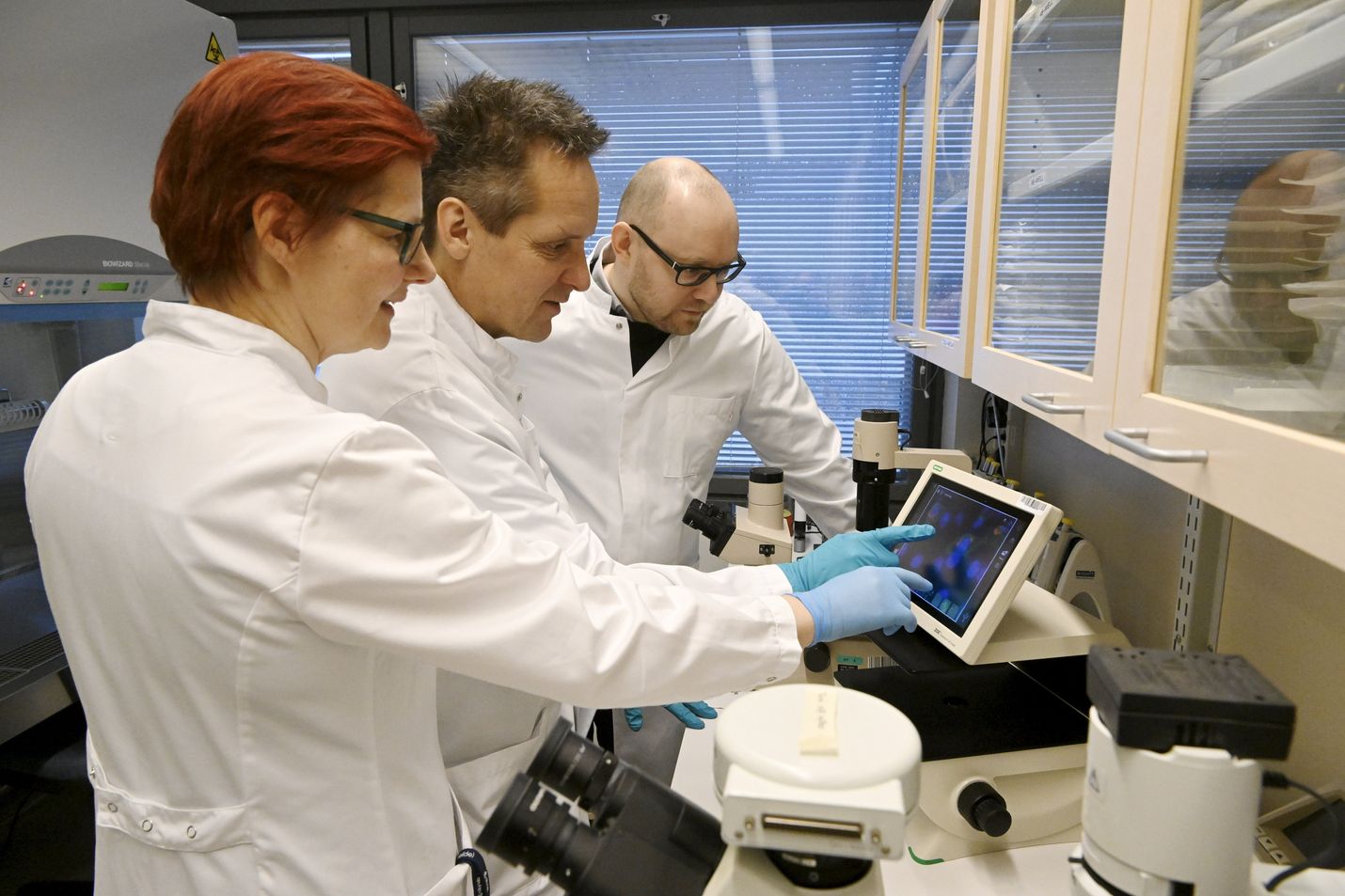 Rokote Laboratories Finlandin tutkimus- ja kehitysjohtaja Erkko Ylösmäki (oik.) sekä rokotteen kehitystyössä mukana olleet tutkijat Sanna Mäki (vas.) ja Riku Fagerlund tutkivat rokotetta mikroskooppikuvasta laboratoriossa Helsingissä 19. tammikuuta 2023. Nenään annettavan suomalaisen koronarokotteen kehittely on edennyt viime vuoden viivästysten jälkeen. Kliininen tutkimus ja vapaaehtoisilla tehtävät kokeet on tarkoitus aloittaa tämän vuoden lopulla.
