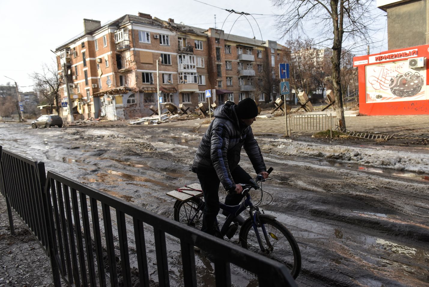 Etulinjan Bahmutissa Itä-Ukrainassa ei ole enää toimivaa sähköä, lämmitystä, vettä tai kaasua. Vaara haavoittua tai kuolla Venäjän tulituksesta on suuri, joten kaupunkiin jääneet viettävät pääosan ajastaan suojissa ja kellareissa. Mies polki pyöräillä Bahmutissa 20. tammikuuta 2023.