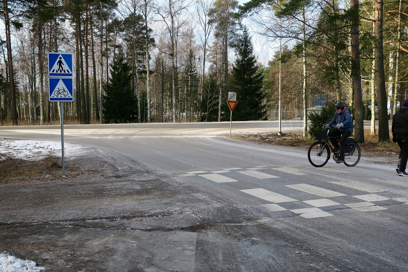 Vasemmalla suojatiemerkin alapuolelle oleva liikennemerkki B7 kertoo väistämisvelvollisuutta pyöräilijän ylityspaikassa.