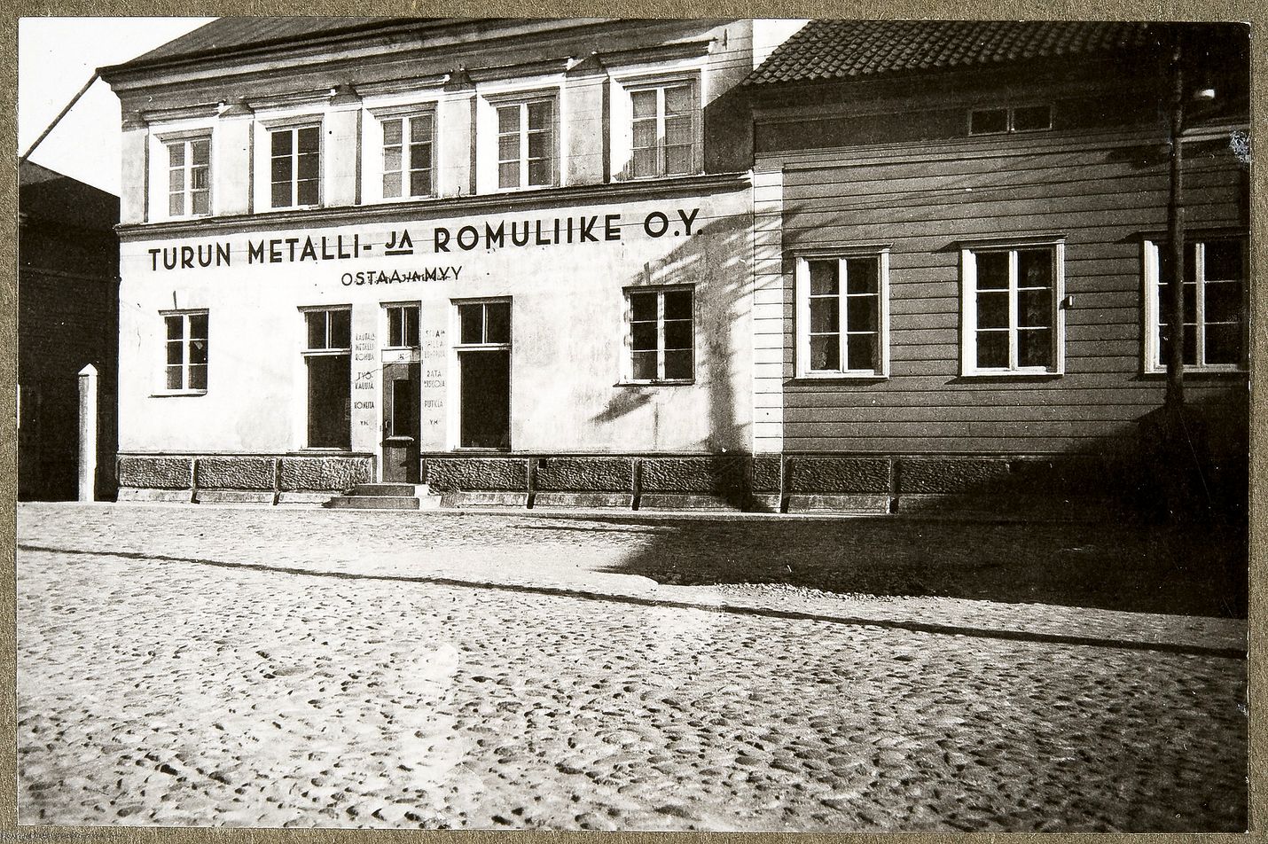 1940-luvulla kuvatun Pinnalan kivirakennuksen julkisivuun on maalattu Turun metalli ja romuliike Oy. Talossa on toiminut myös lasi-, kehys- ja huonekalukauppa. 