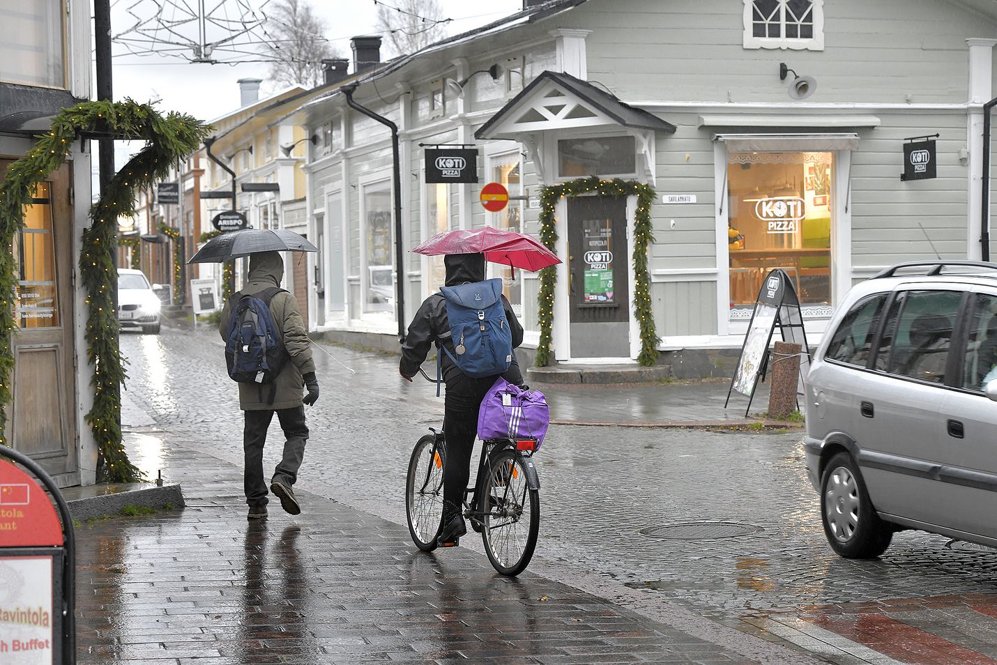 Jalankulkijat, pyöräilijät ja autot jakavat saman katutilan Vanhassa Raumassa.