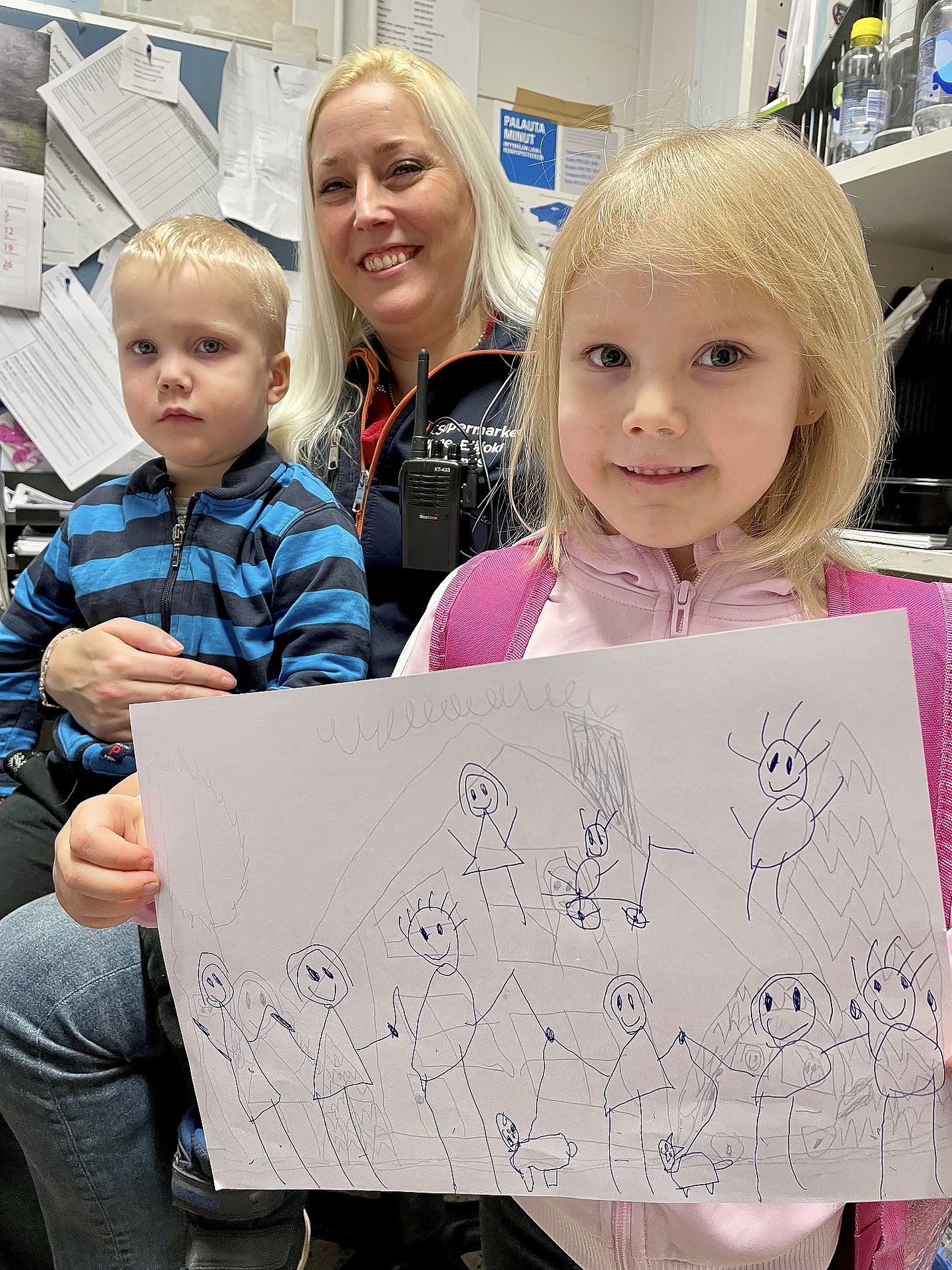 Armas, 2, ja Ilona, 5, ovat tuttu näky K-Supermarket Rosmariinissa, jossa Irene Elläjoki on toiminut kauppiaana jo 10 vuotta. Ilona piirsi äitinsä toimistossa kuvan perheestään, johon kuuluu seitsemän lasta ja kaksi koiraa. 