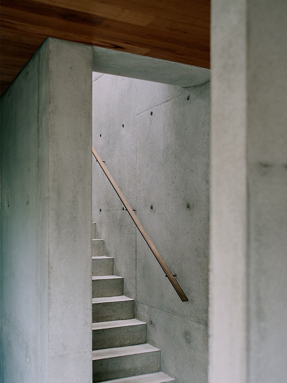 Kuva. jossa Edition Officen suunnittelema rakennus: Hawthorn House. Kuvassa tarkastellaan talon betonista portaikkoa, jossa on messinkiset kaiteet.