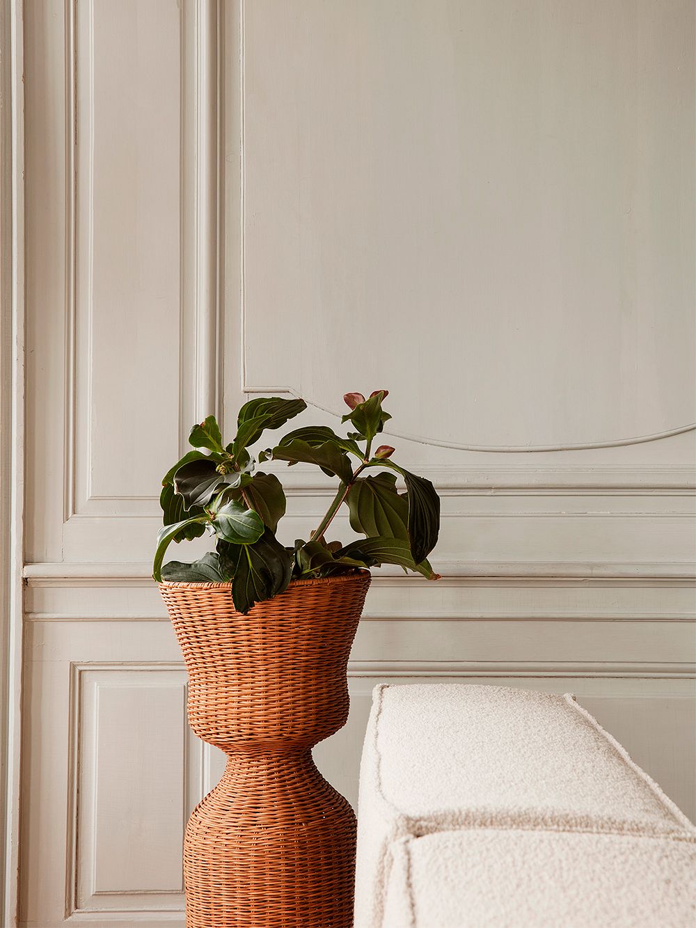 An image of ferm LIVING's Agnes plant stand as part of the living room decor.