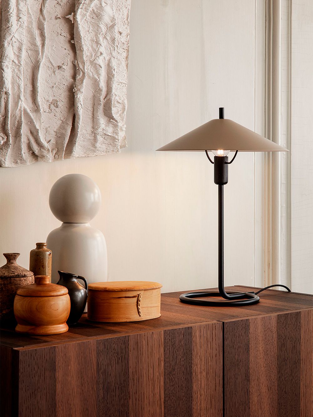 An image of ferm LIVING's Filo table lamp as part of the living room decor.