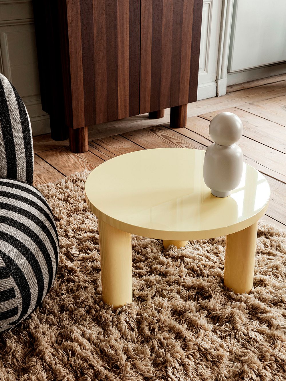 An image of ferm LIVING's yellow Post coffee table and wooden Post storage cabinet as part of the living room decor.