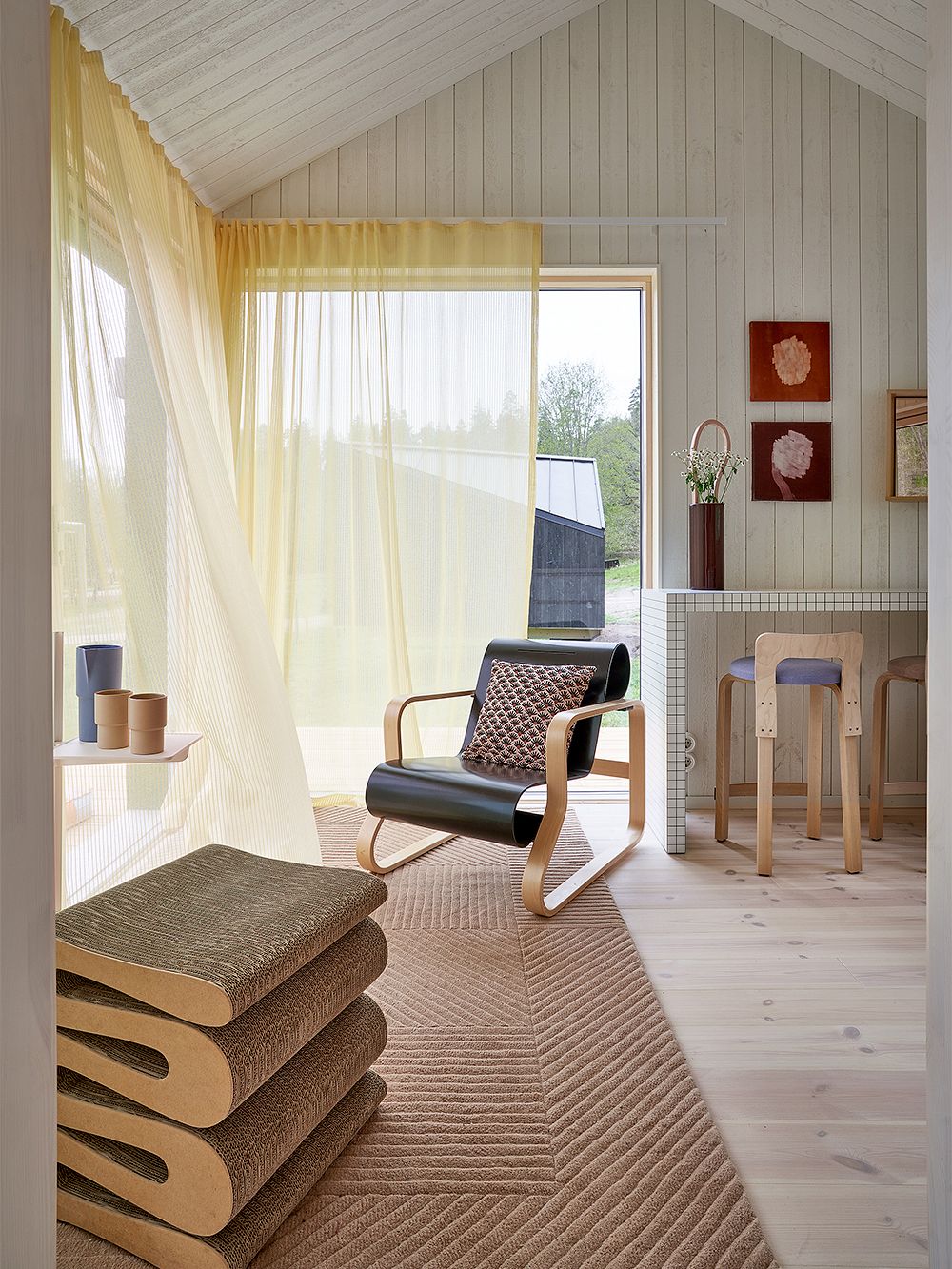 Kuva, jossa Fiskars Biennalen Arkkitehdin talo -näyttelyssä mukana oleva Sommarnöjenin Sommar 30 -mökki: olohuoneen sisustus.