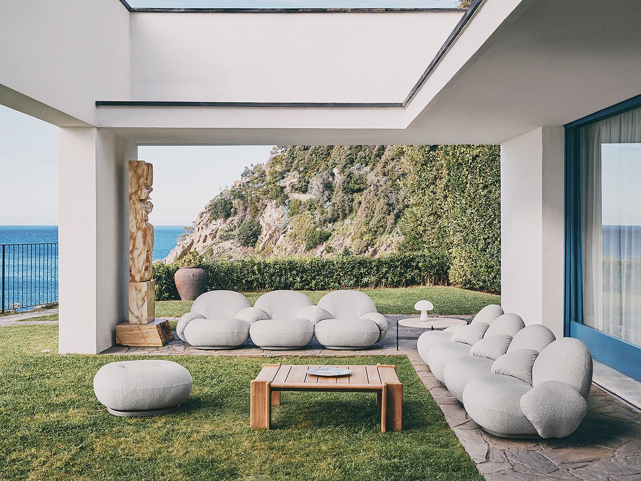 An image of GUBI's Pacha Outdoor armchairs and Atmosfera coffee table on the patio.